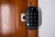 a black electronic lock on a wooden door