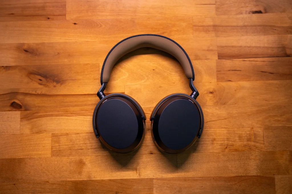 Sennheiser Momentum 5 Wireless: słuchawki z ANC, które skutecznie odcinają od świata 11 słuchawki ustawione frontalnie, leżą na biurku z drewna